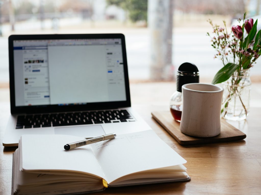 why I write, person's writing notebook and computer on table