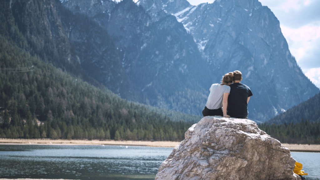 happy couple sitting on a rock talking about what love is
