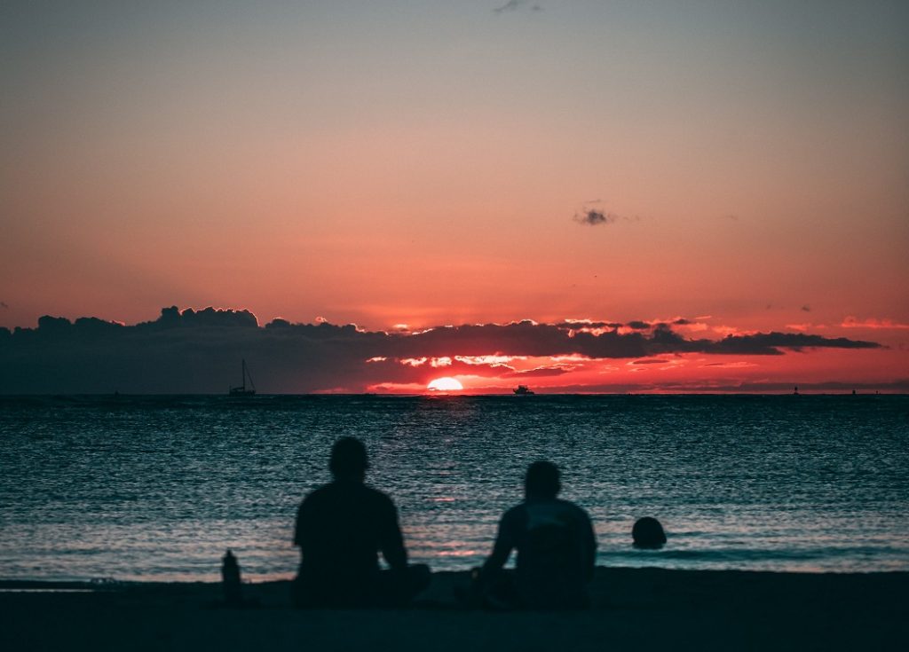 two people sitting by the water wishing for love