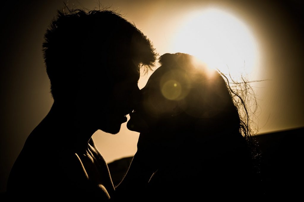 couple kissing passionately at sunset