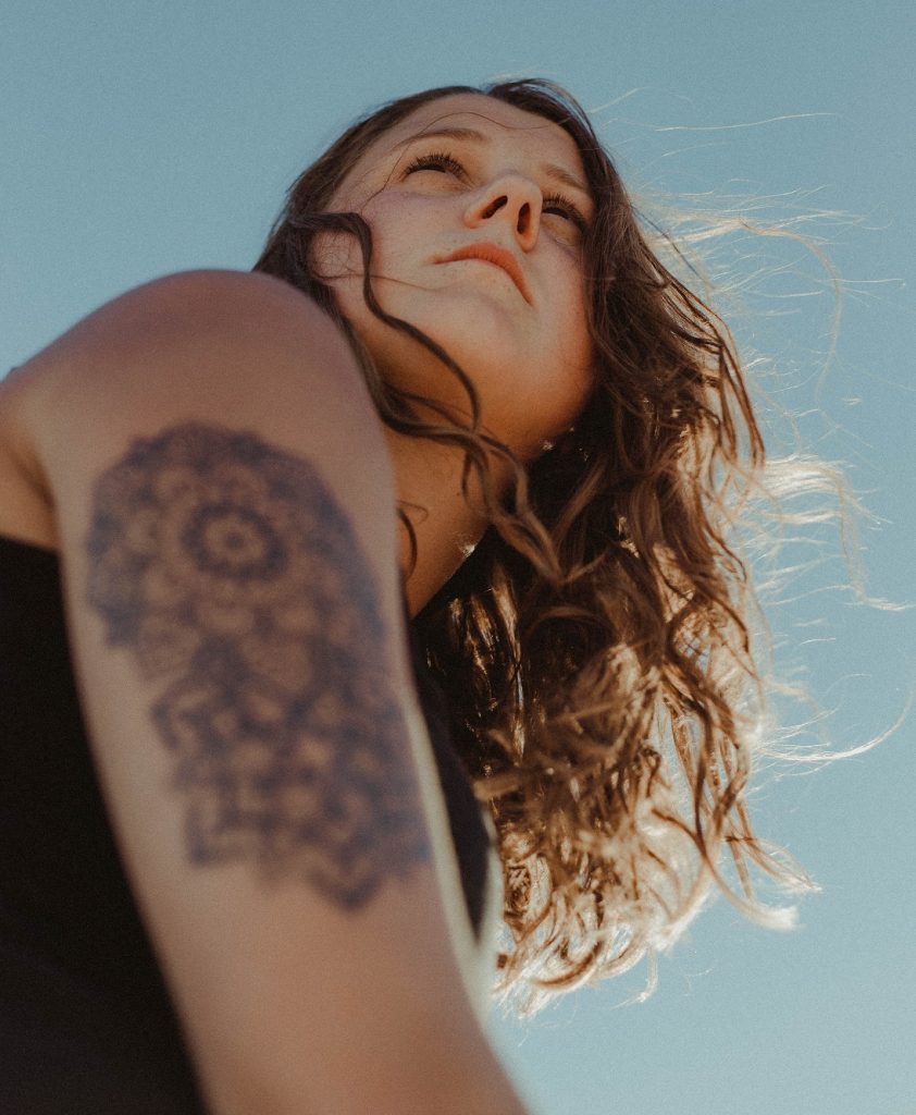 girl with tattoo looking out at the sky