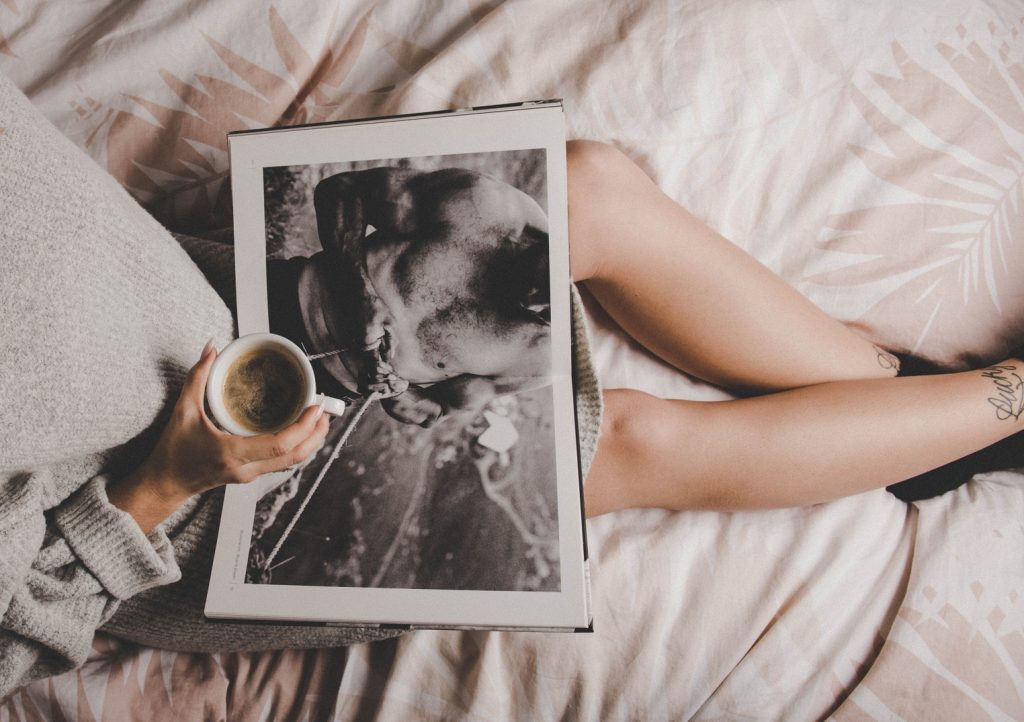 girl holding black and white magazine on her lap