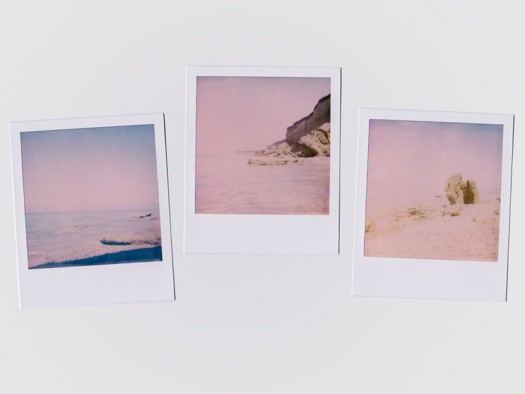 Polaroid pictures on a white desk poetry about your lips and longing