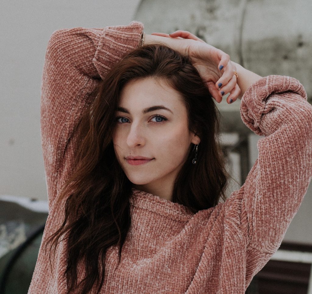 girl with arms above her head and confident face