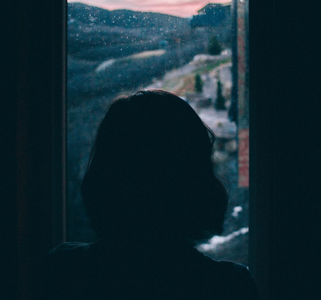 girl looking out small window