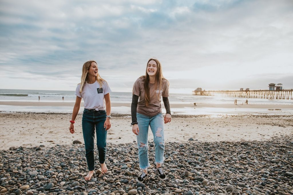 girls laughing together on the beach