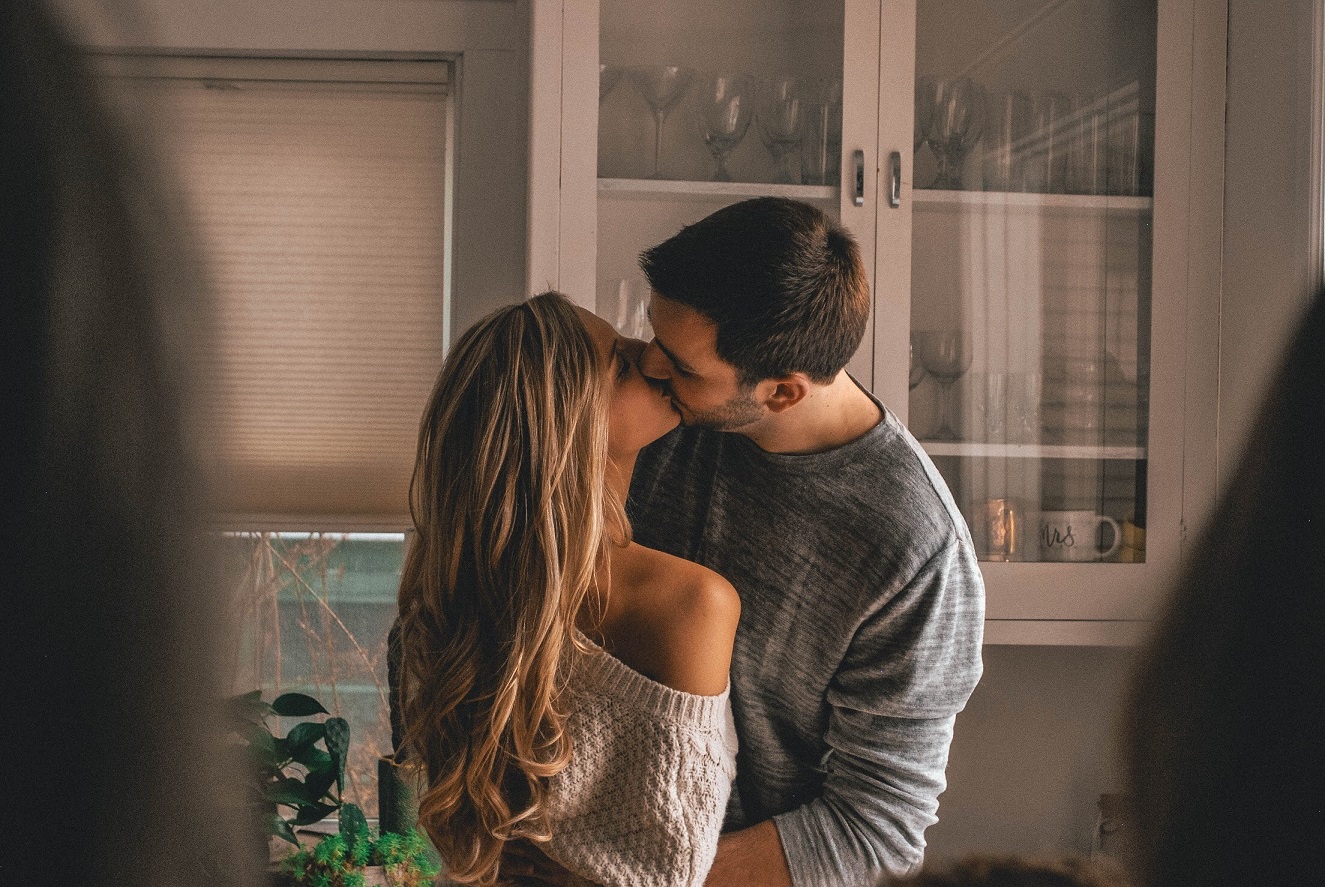 couple kissing in kitchen