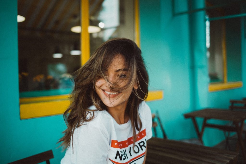 girl with hair in her face smiling