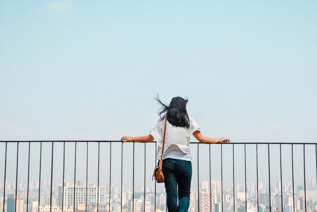 girl leaning over fence
