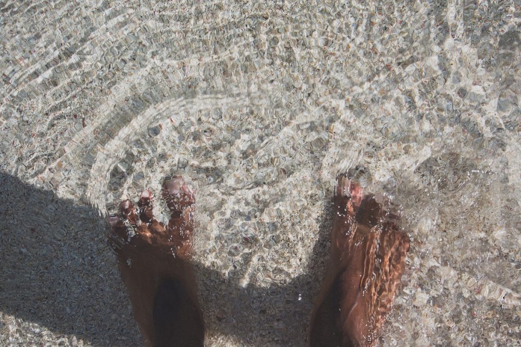 girl with feet in the ocean water, embracing who I am