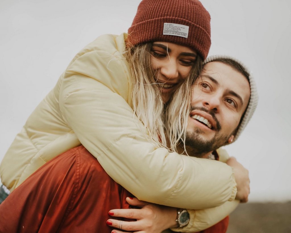 couple hugging with girl sitting on his back