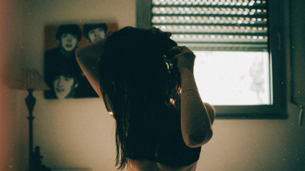 girl looking down in dark shadowed room with a monster in her head