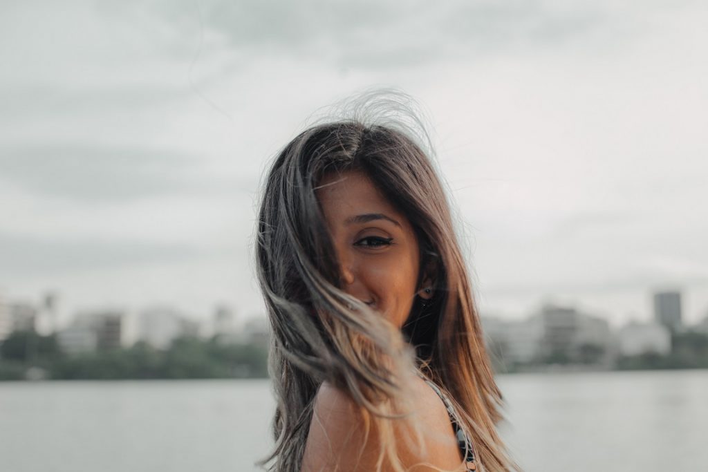 girl with smile staring at camera and hair in her face