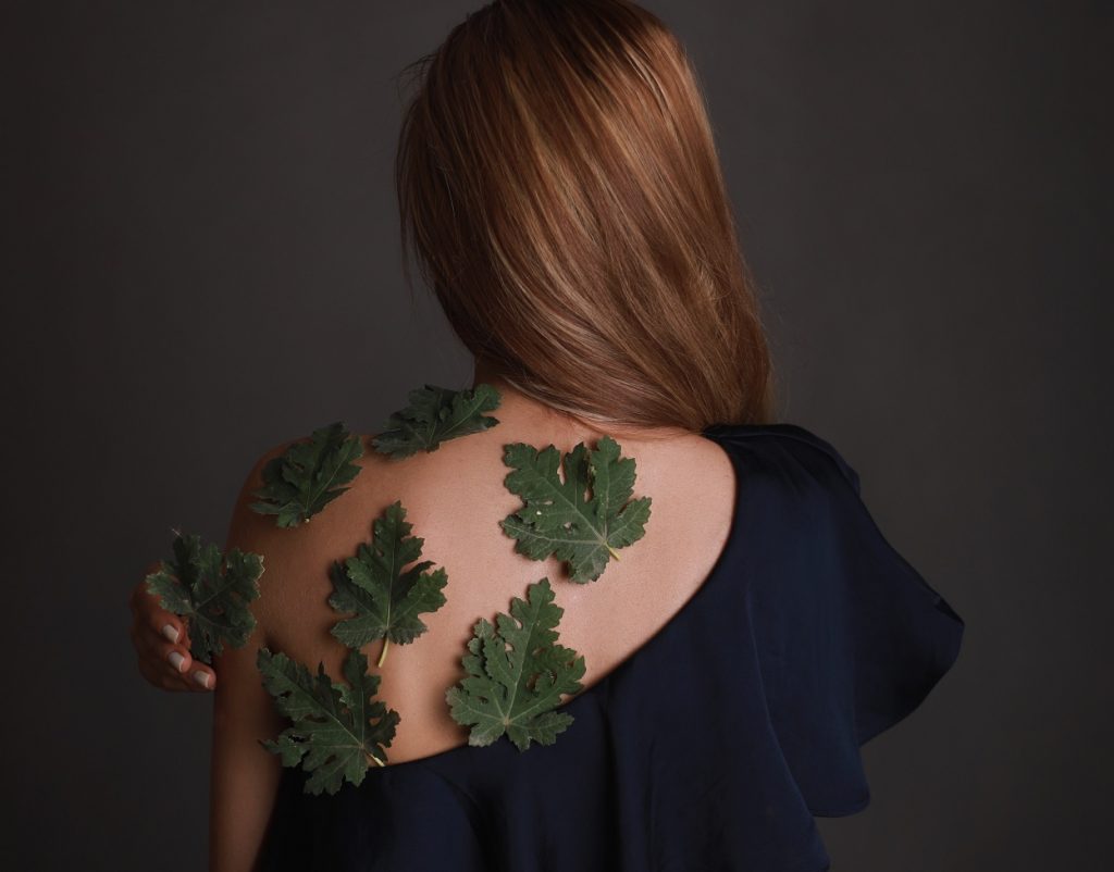girl with leaves on her back facing away from the camera