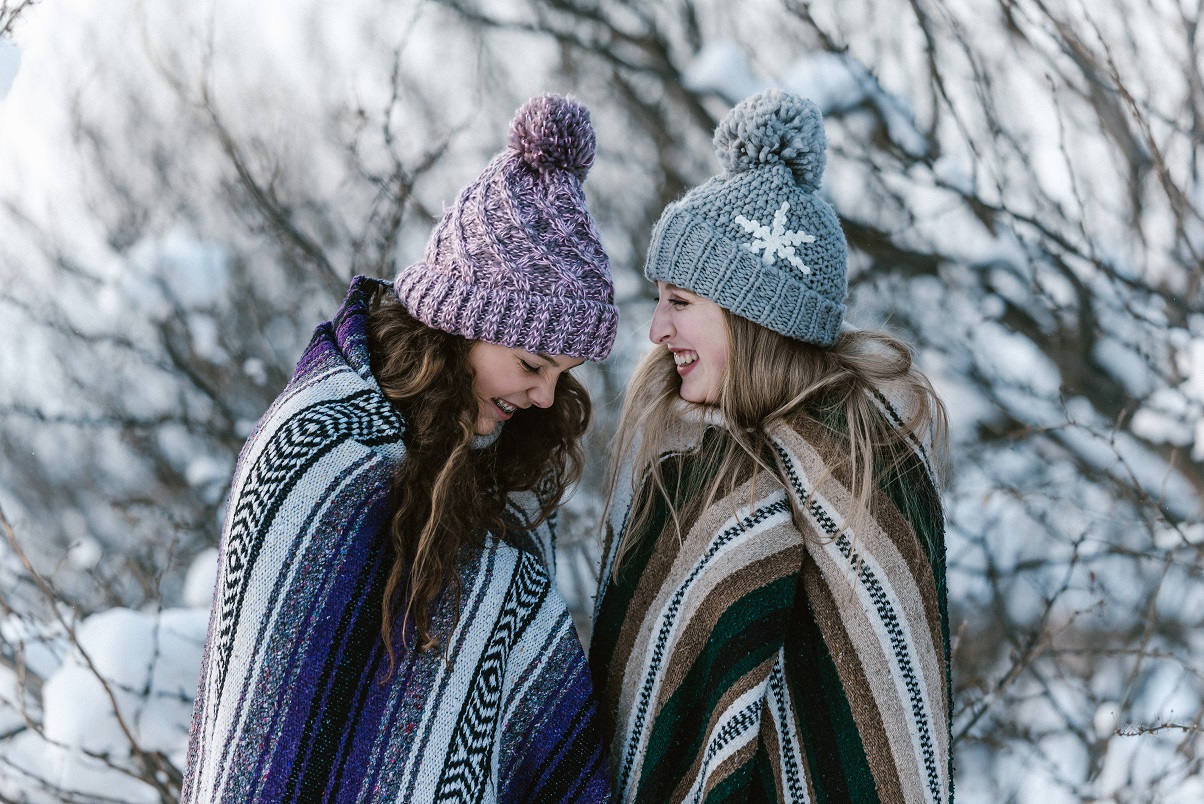 happy girls laughing in winter snowstorm