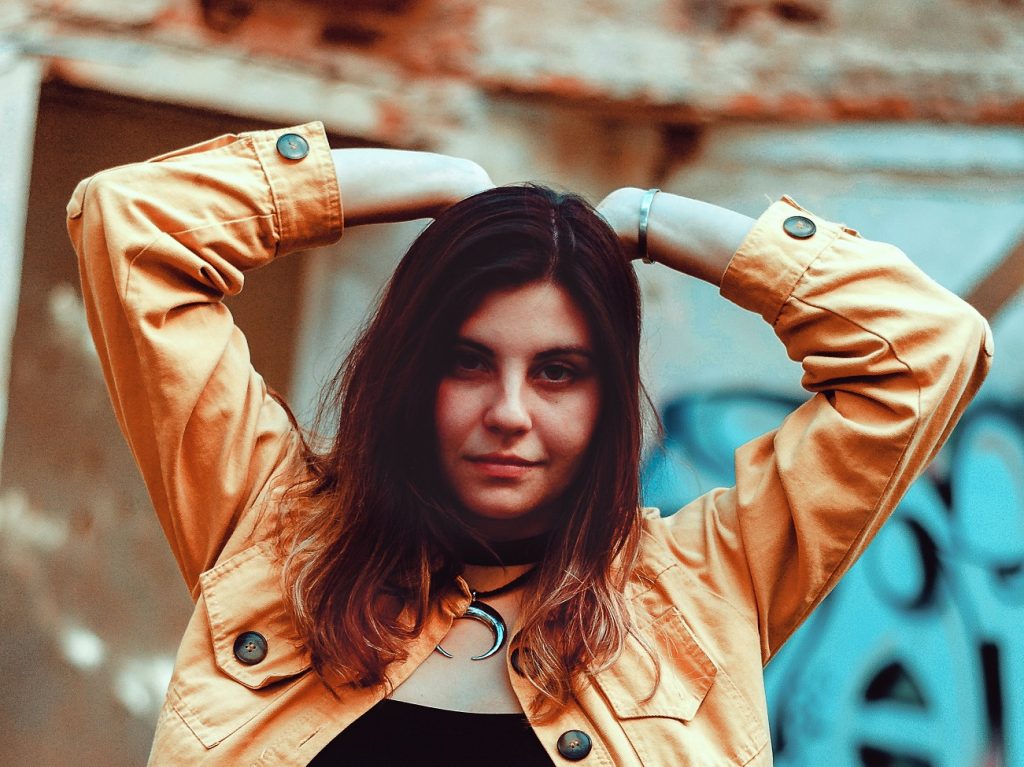 girl with serious face and arms above head