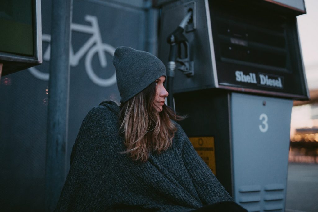 somber girl sitting in front of a train station