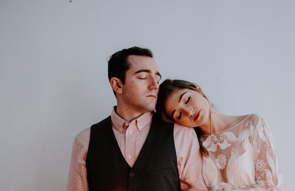 couple with close eyes leaning on each other's shoulders