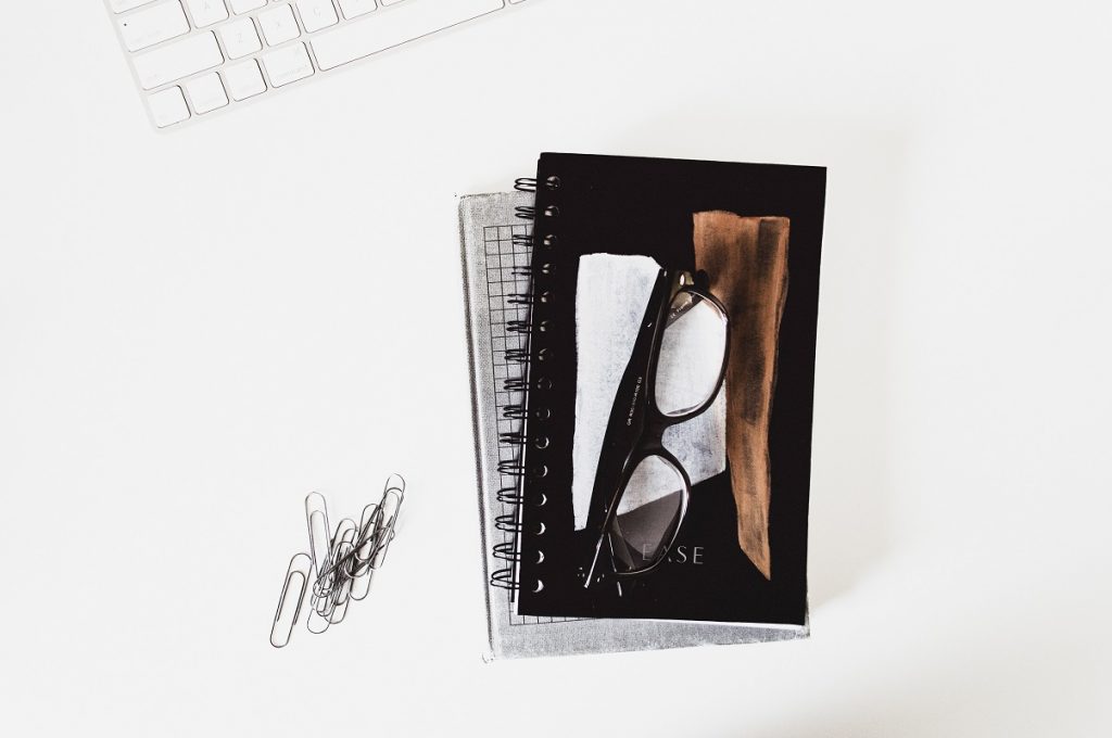 notebooks and glasses on white table