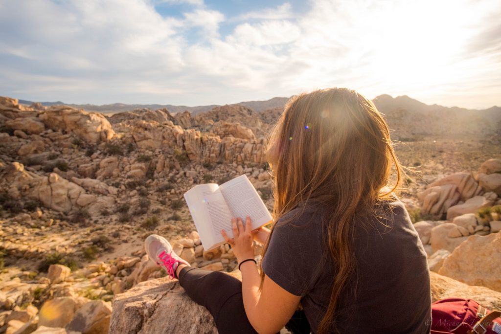 girl with book on mountain top