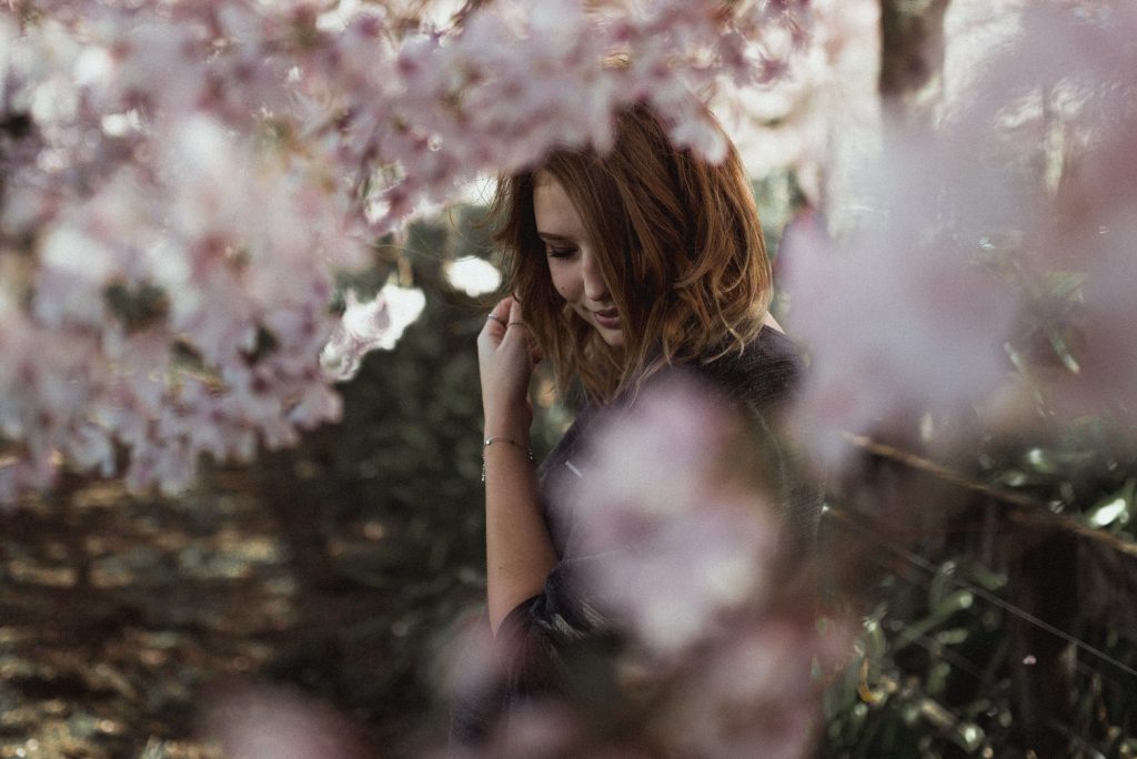 girl half-hidden by flowers, learn to live in god's holiness