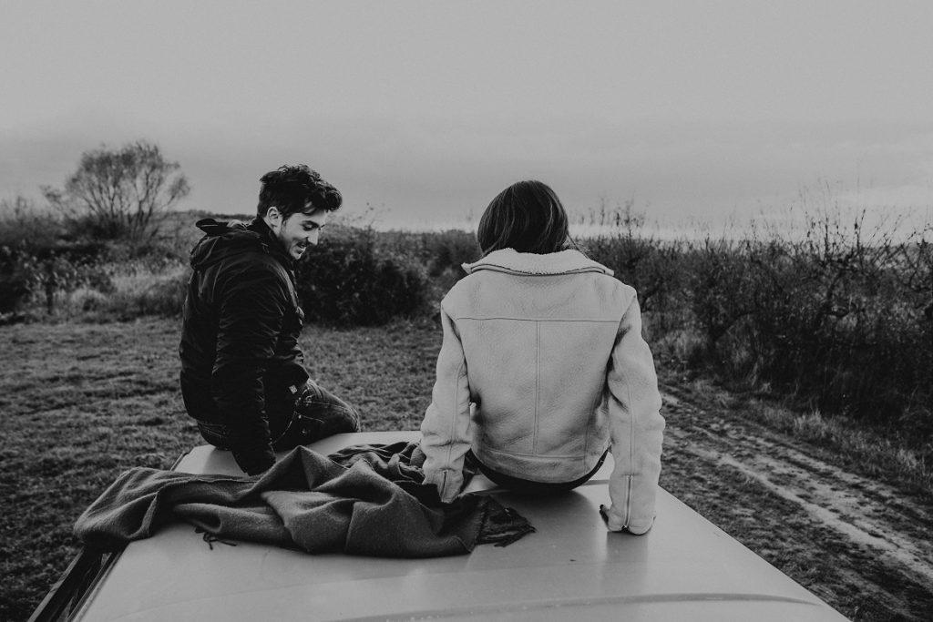 happy couple sitting on a car, maybe I've been wrong about love