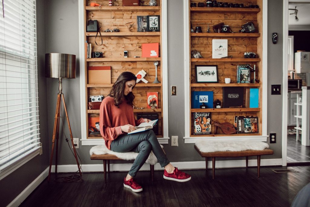 girl with book in front of shelves, what I'm reading this week
