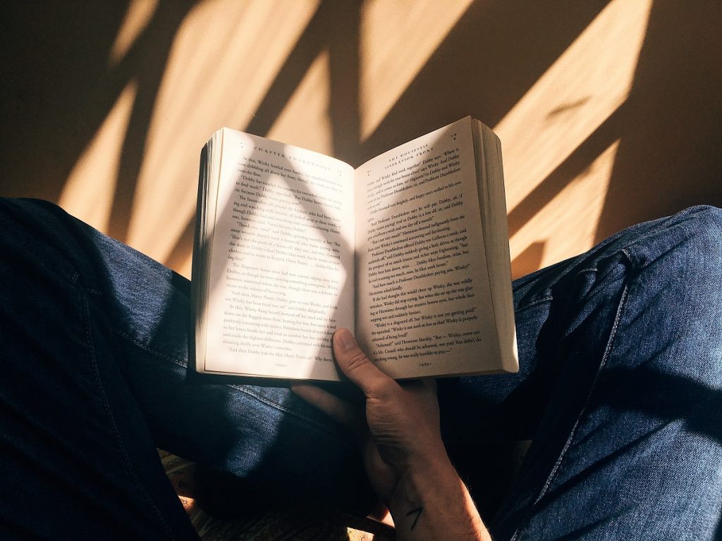person holding book in lap