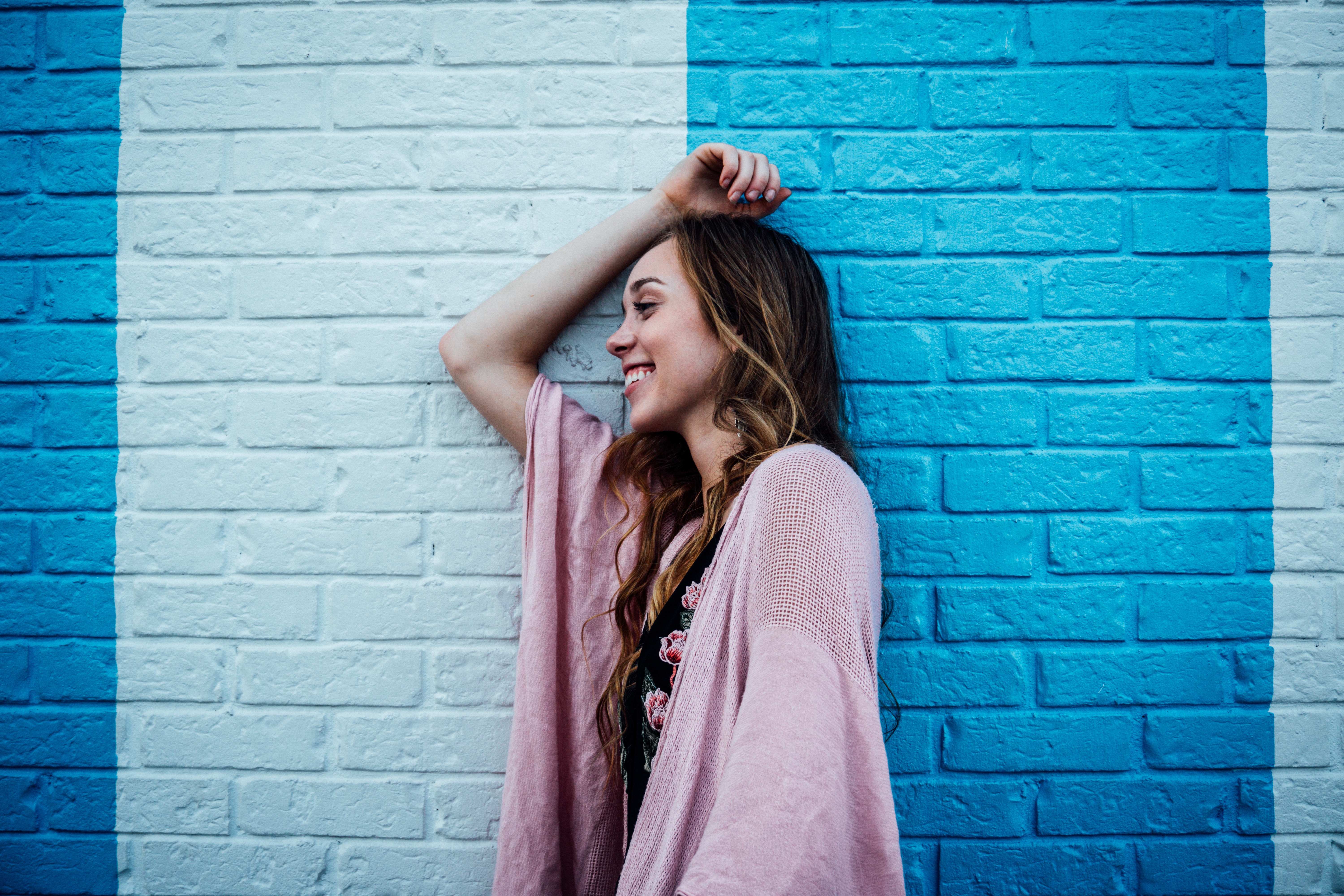 girl smiling by blue brick wall
