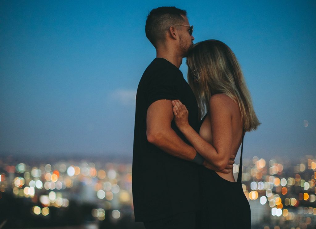 happy couple embracing by skyline