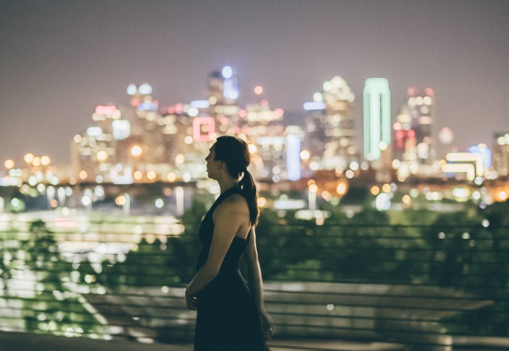 girl looking at night skyline, supposed to be lost