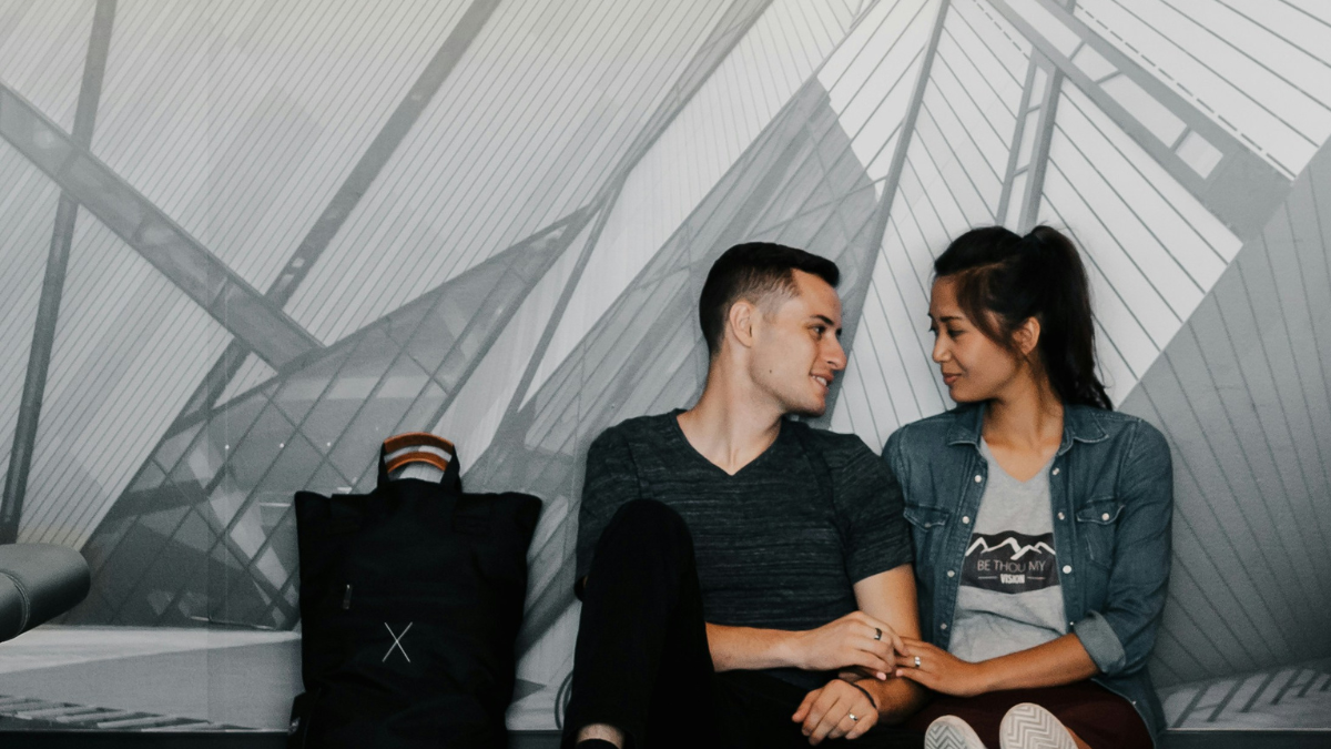 couple holding hands with suitcases