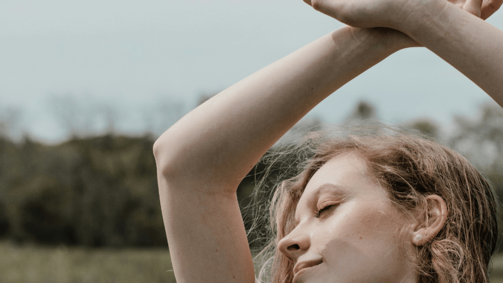 joyful woman with her hands up above her head singing