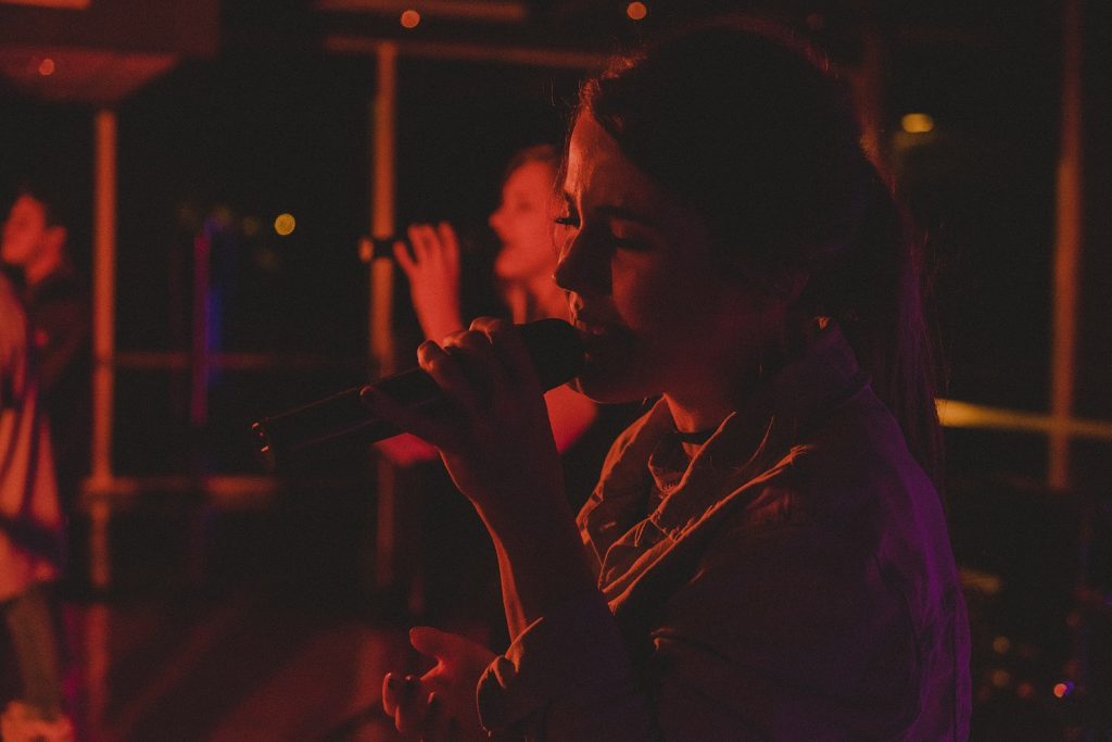 woman singing in a microphone, talented young artists to follow in 2019