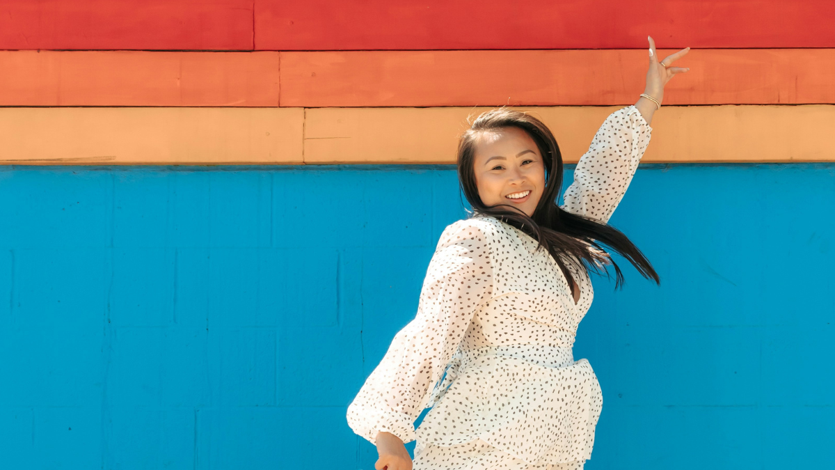 confident woman jumping with a peace sign