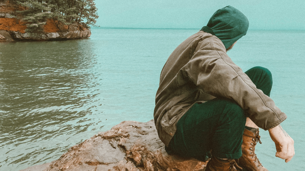 man sitting on a rock overcoming obstacles in life
