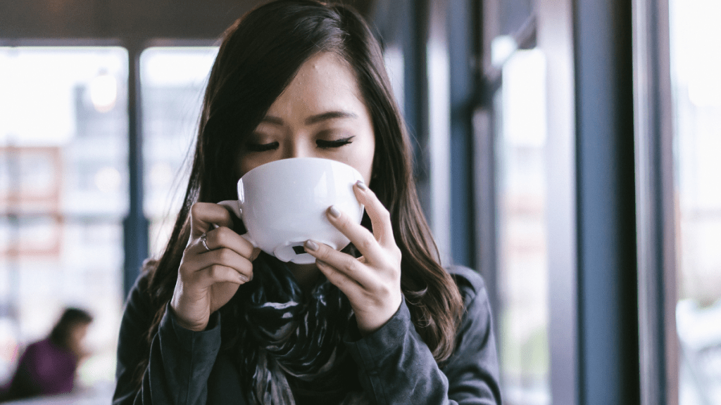 woman sipping coffee trying to mend a broken heart