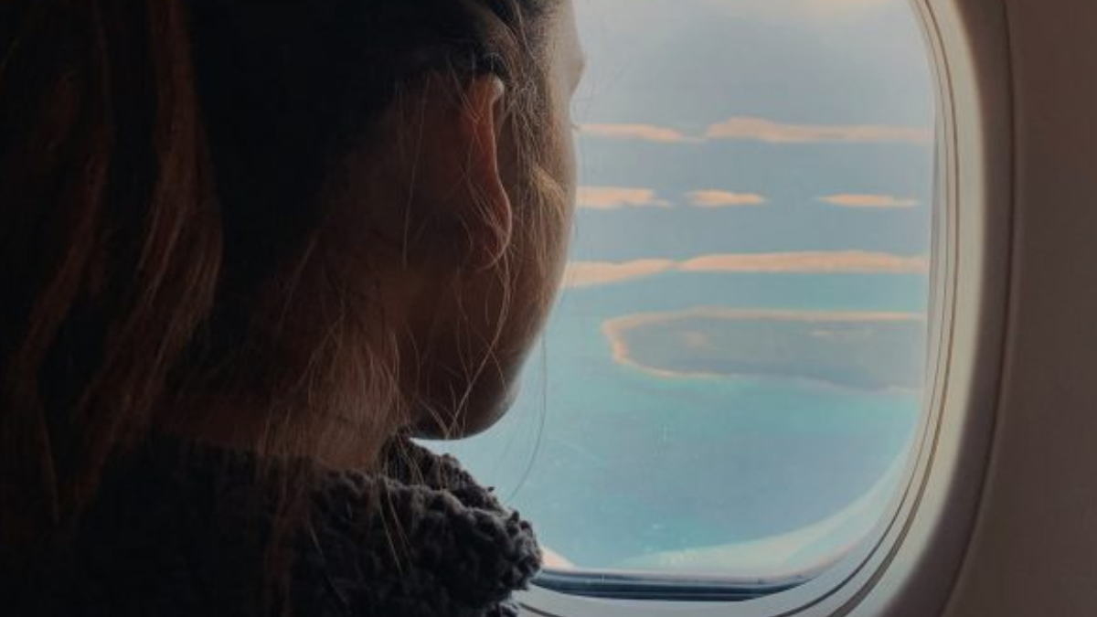 woman looking out of airplane window overcoming depression