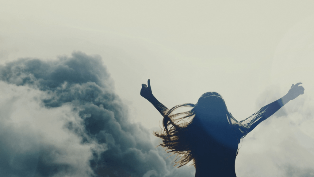 person overcoming addition with hands to the sky for freedom