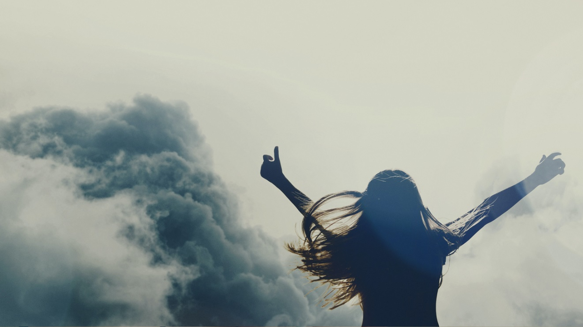 person overcoming addition with hands to the sky for freedom