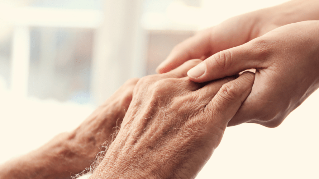 young hands holding elderly person's hands