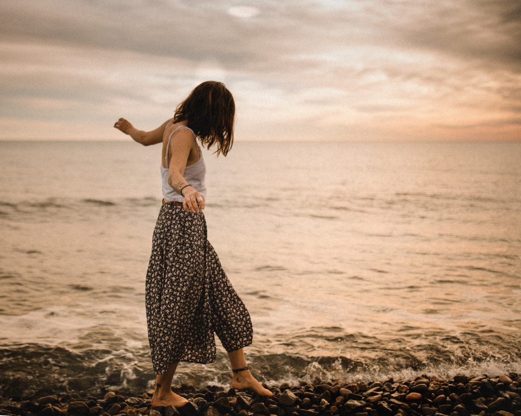 happy woman dancing by beach