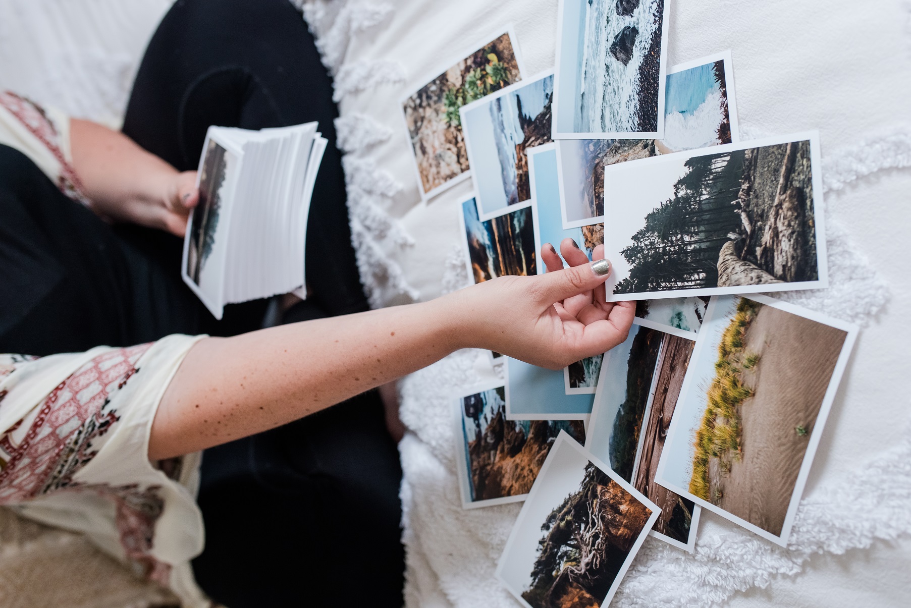 woman holding pictures of the book Revealed At The Edge