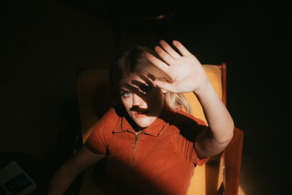 person with hand over her face rewriting the mind