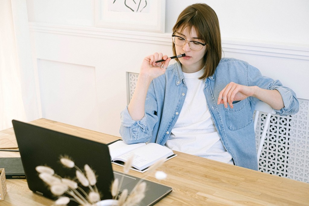 woman blogging and chewing on a pen