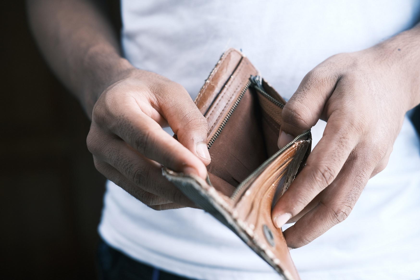 person holding wallet being worried about debt